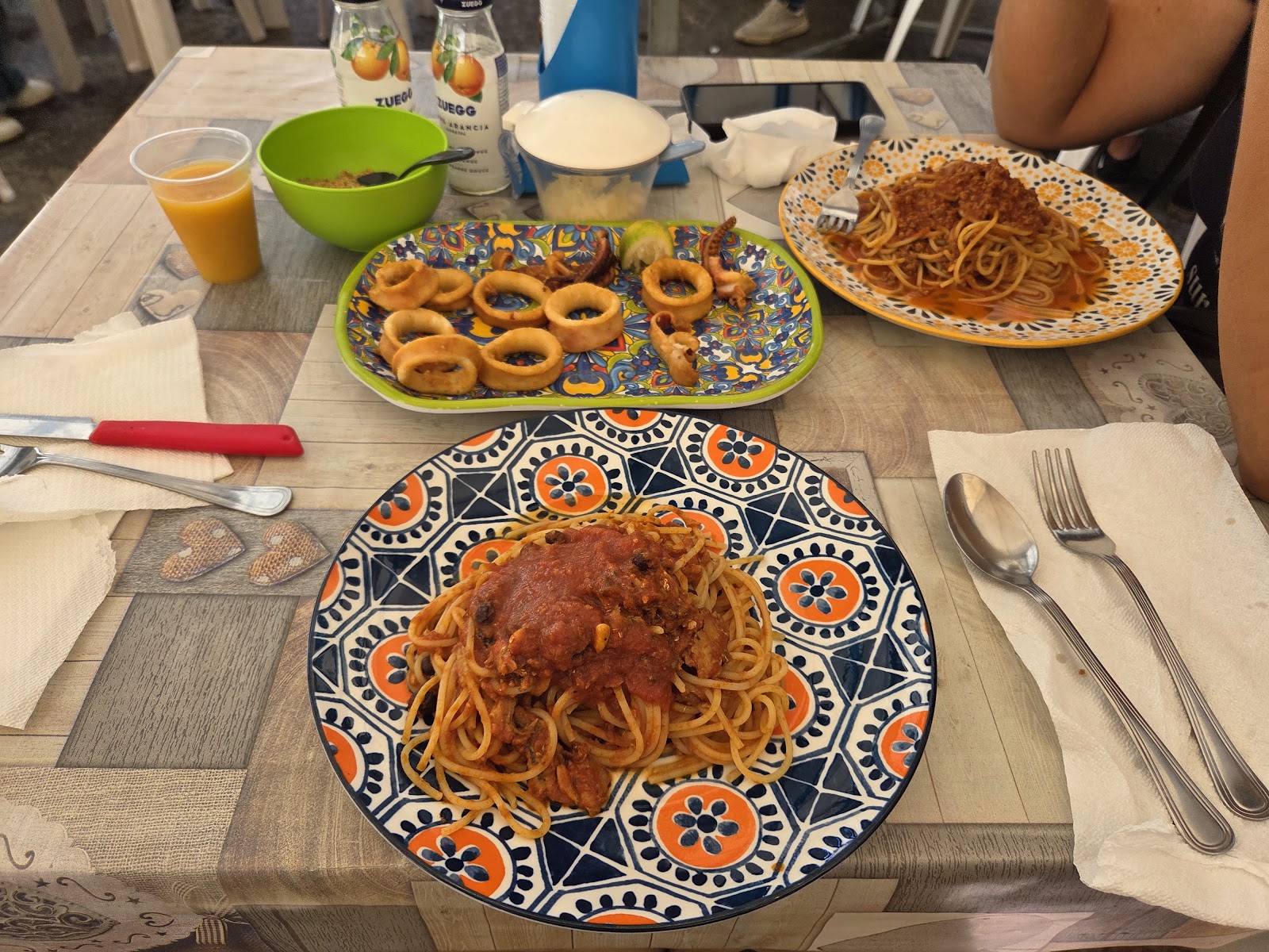 Un tavolo apparecchiato al mercato con due piatti di pasta al ragù